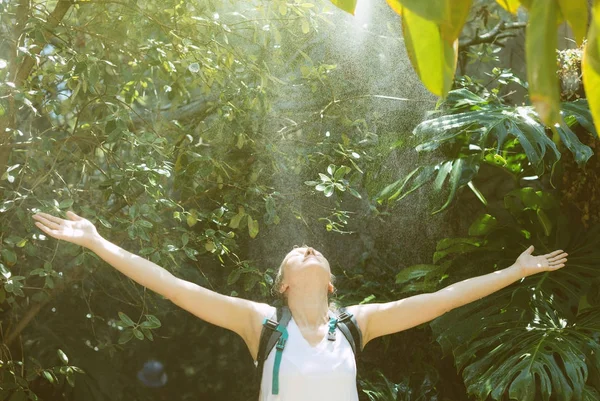 Turista feminino com mochila sob a chuva na selva . — Fotografia de Stock