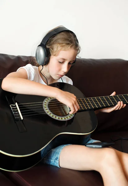 Dziewczynka z słuchawki, gra na gitarze. — Zdjęcie stockowe