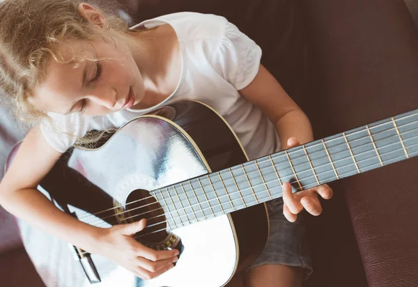 Маленькая девочка играет на гитаре . — стоковое фото