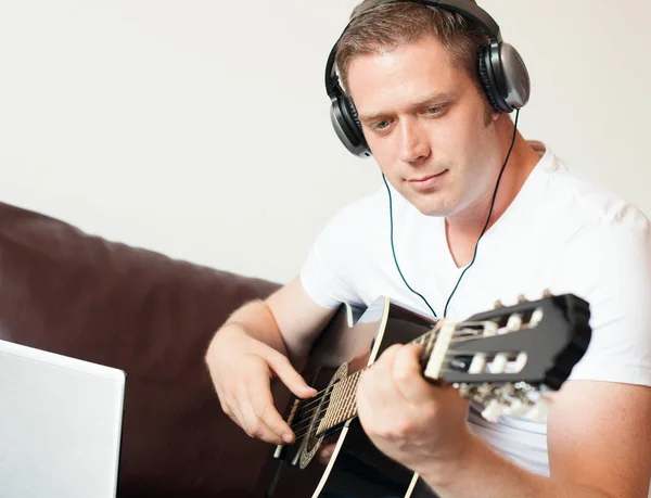 Handsome man with headphones playing the guitar. — Stock Photo, Image