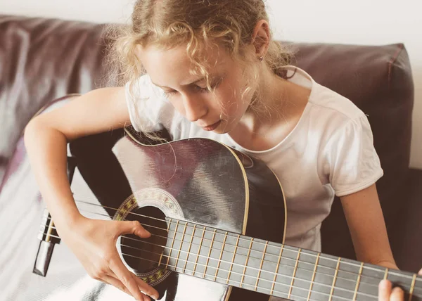 Malá holčička se učí hrát na kytaru. — Stock fotografie