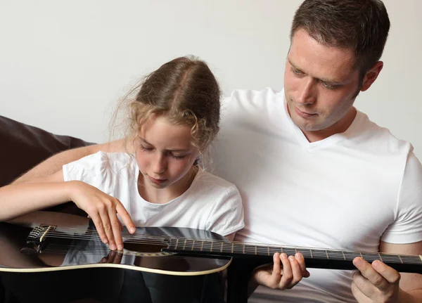 Pappa lär dotter att spela gitarr. — Stockfoto