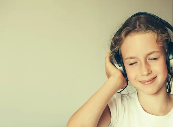 Meisje, luisteren naar de muziek in hoofdtelefoons. — Stockfoto