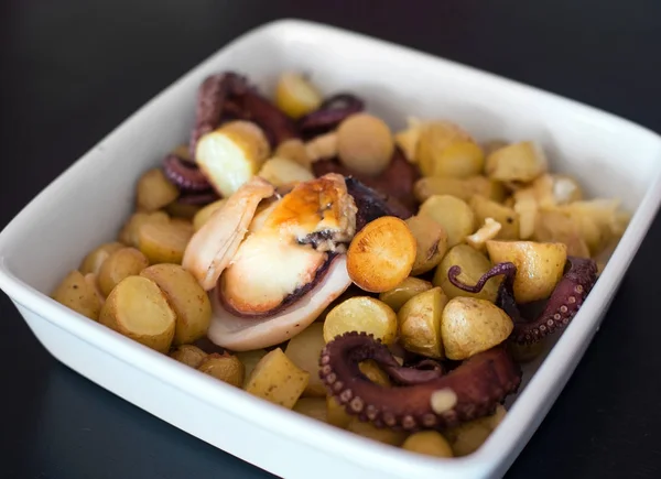 Plaat met gebakken inktvis met aardappelen. — Stockfoto