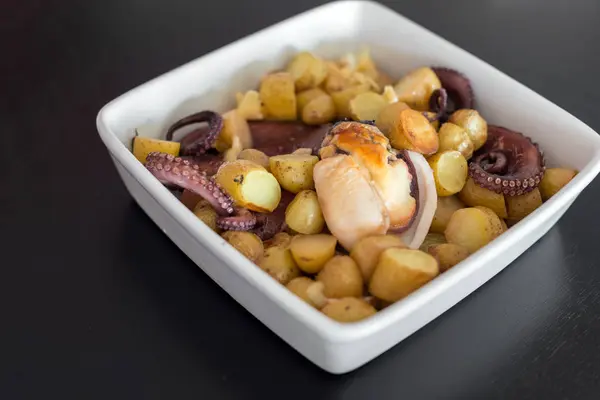 Plaat met gebakken inktvis met aardappelen. — Stockfoto