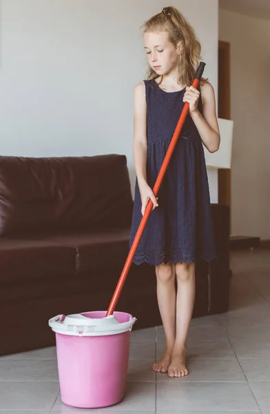 A menina está a limpar o apartamento. Limpa o chão. . — Fotografia de Stock