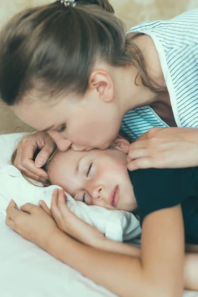 Mama całuje córkę przed pójściem do łóżka. — Zdjęcie stockowe