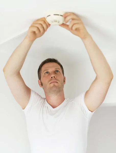 Male technician installing smoke detector at home. — Stock Photo, Image