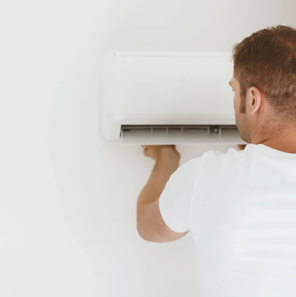 Tecnico maschio che installa impianto di climatizzazione . — Foto Stock