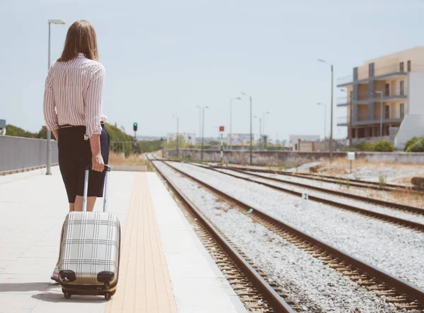 Kobieta z bagażem czeka na jej pociąg. — Zdjęcie stockowe