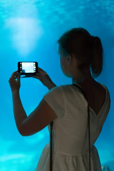 Frau macht Fotos im Aquarium. — Stockfoto