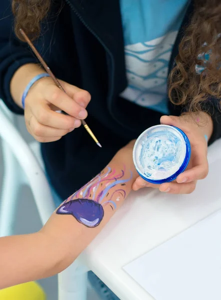 Художник малює восьминіг на руці дитини . — стокове фото