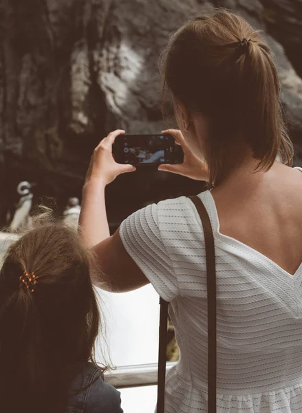 Kadın ve kızı hayvanat bahçesinde penguenleri fotoğraflar yapmak. — Stok fotoğraf