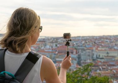 Woman traveller with camera shooting video. clipart