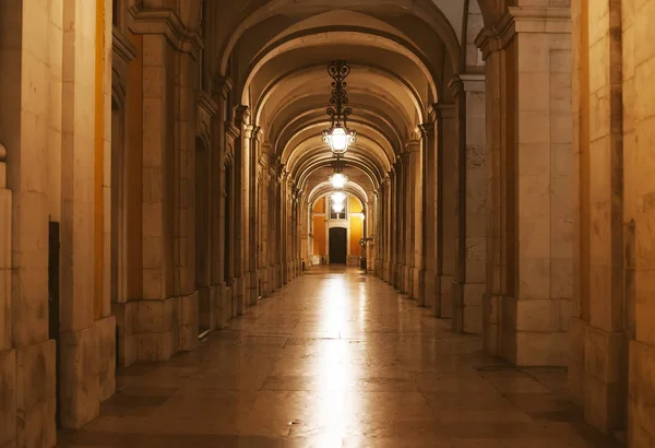 Archway ao longo da Praça do Comércio em Lisboa à noite . — Fotografia de Stock