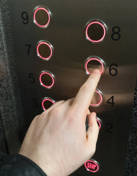 Man pressing button inside elevator.