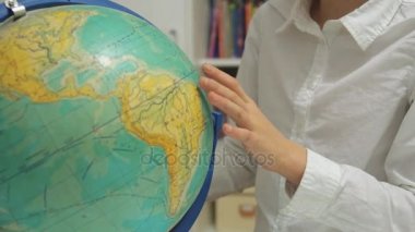 Küçük kız evde dünya okuyor.