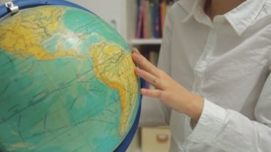 Küçük kız evde dünya okuyor.