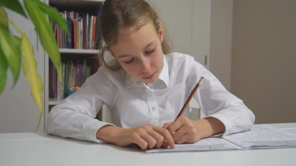 La niña está haciendo los deberes en casa. . — Vídeos de Stock