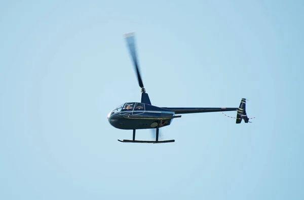 Small private helicopter in the sky.