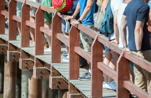 People standing in a queue on the bridge. — Stock Photo, Image