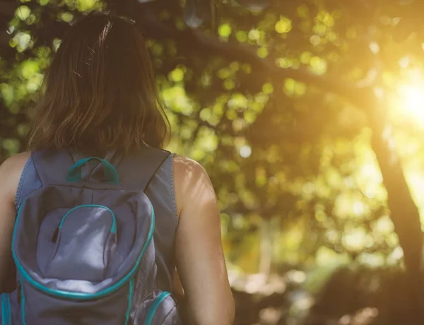 Vrouw met rugzak in het forest. Uitzicht vanaf de achterkant. — Stockfoto