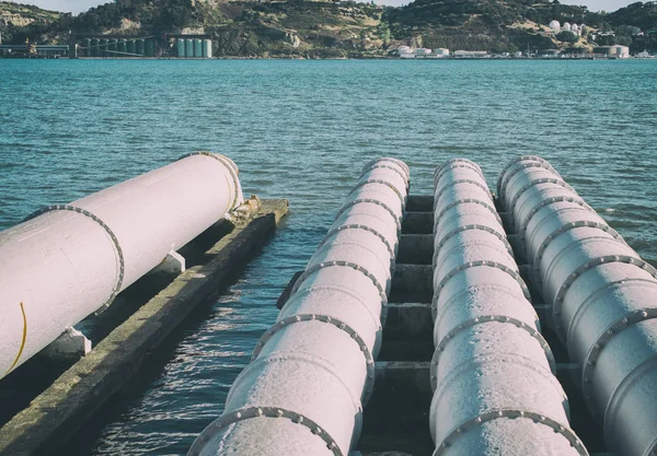 Large metal pipes heading to the river. — Stock Photo, Image