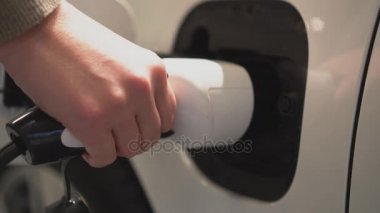 Elektrik tutan el elektrikli araba şarj etmek için fiş.
