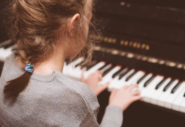 Küçük kız piyano çalmayı öğrenme.