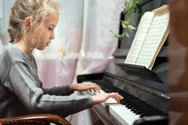 Маленька дівчинка вчиться грати на піаніно . — стокове фото