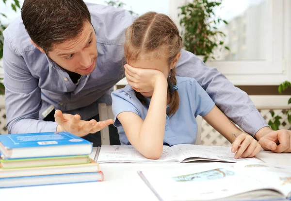 O pai está zangado porque a filha não quer fazer os trabalhos de casa. . — Fotografia de Stock
