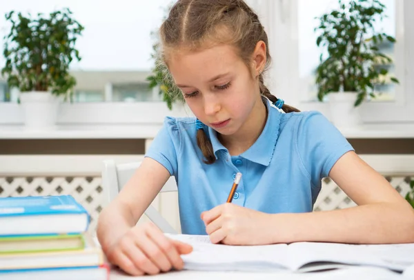 Маленька дівчинка робить домашнє завдання вдома . — стокове фото
