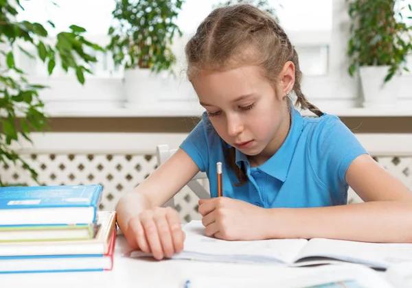 Küçük kız ödevini evde yapıyor. — Stok fotoğraf