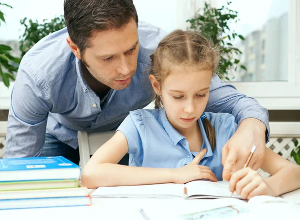 Vader dochter helpen met huiswerk thuis. — Stockfoto