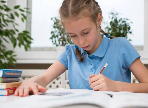 Küçük kız ödevini evde yapıyor. — Stok fotoğraf