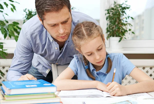 Father helping daughter with homework at home. — Stock Photo, Image