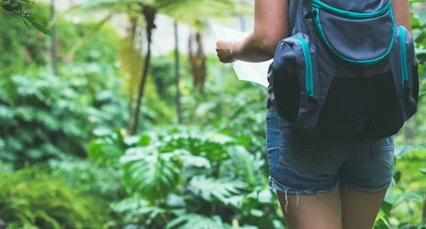 Γυναίκα ταξιδιωτών με χάρτη και σακίδιο στη ζούγκλα. — Φωτογραφία Αρχείου