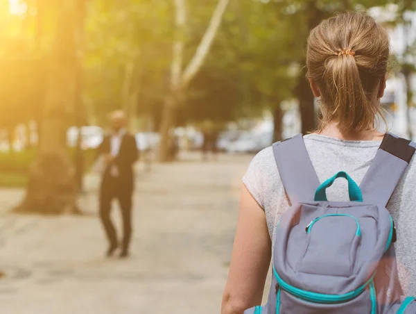 Kvinnlig turist med ryggsäck promenader i staden. Från baksidan. — Stockfoto