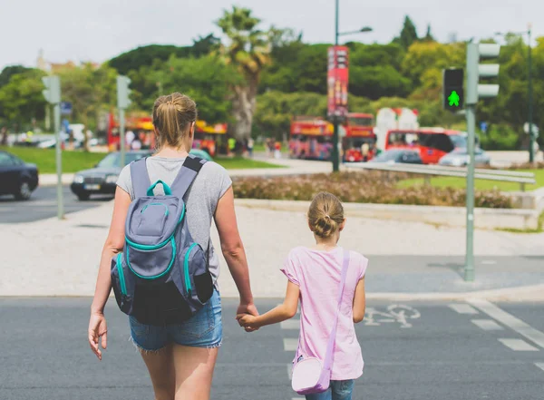 Madre e figlia che attraversano la strada. Vista posteriore . — Foto Stock