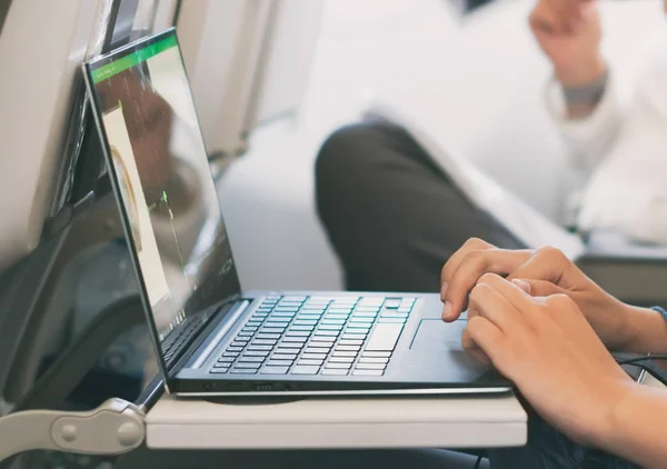 Kobieta korzysta z laptopa w samolocie. — Zdjęcie stockowe
