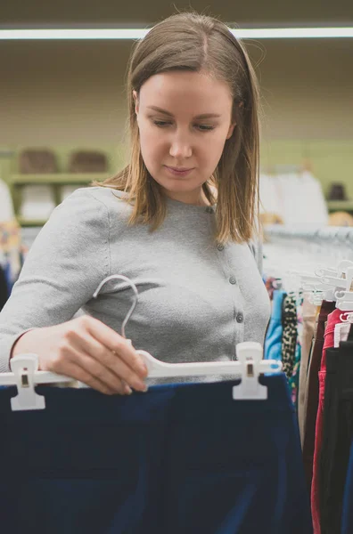 Vrouw kiezen broek in kledingwinkel. — Stockfoto