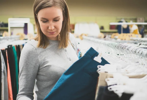 Woman choosing pants in clothing store. — Stock Photo, Image