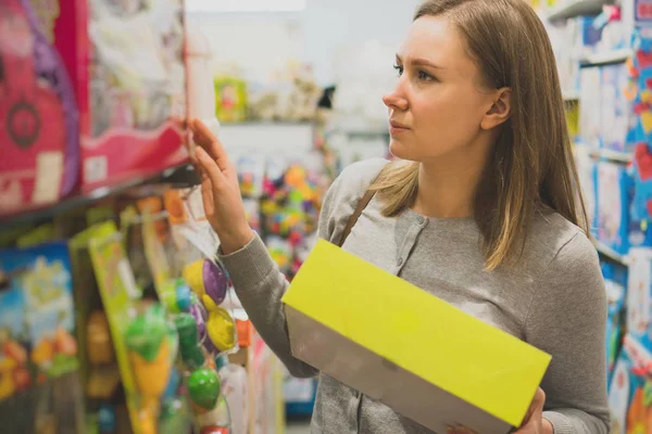Vrouw speelgoed in een kinder winkel kiezen. — Stockfoto