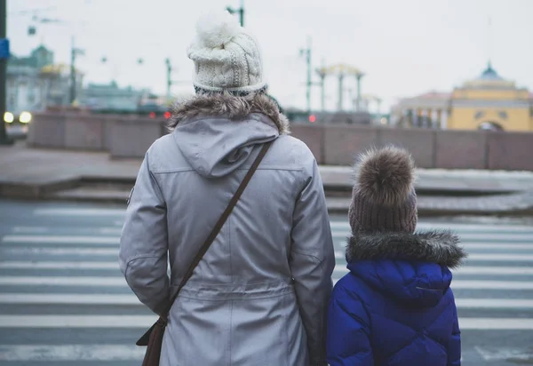 Мати і дочка переходять дорогу. Вид ззаду . — стокове фото