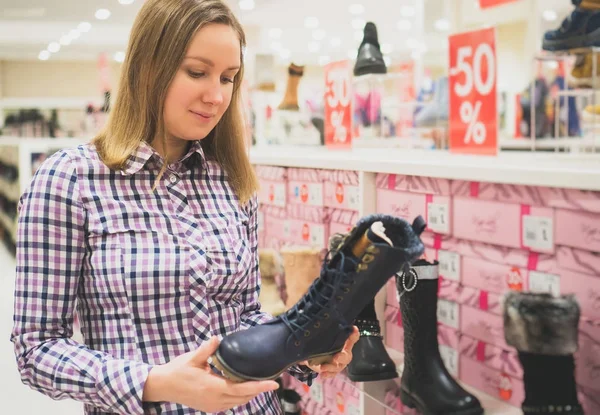 Красива жінка вибирає зимове взуття в торговому центрі . — стокове фото