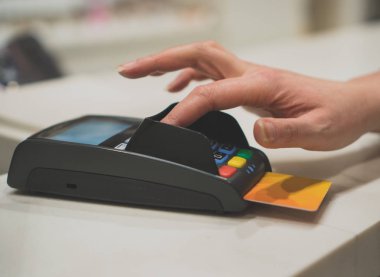 Kadın ödeme banka alışveriş merkezinde terminal yapar.