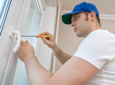 Profesyonel tamirci evde pencere kolunu tamir ediyor..