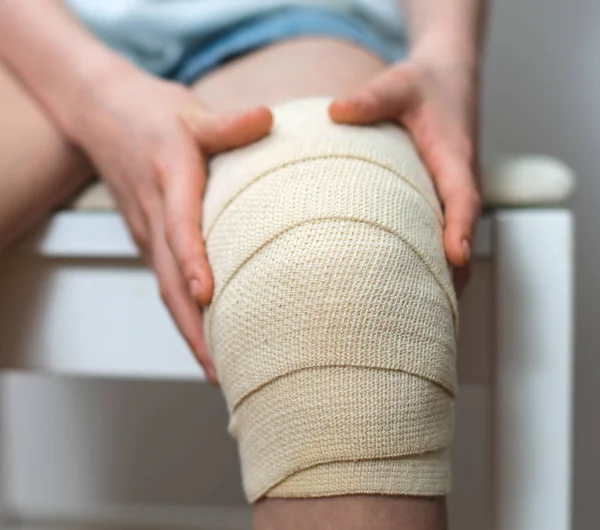 Barn knä med elastisk bandage på det. — Stockfoto