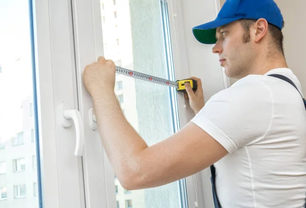 Handyman measuring window for cassette roller blinds. — Stock Photo, Image