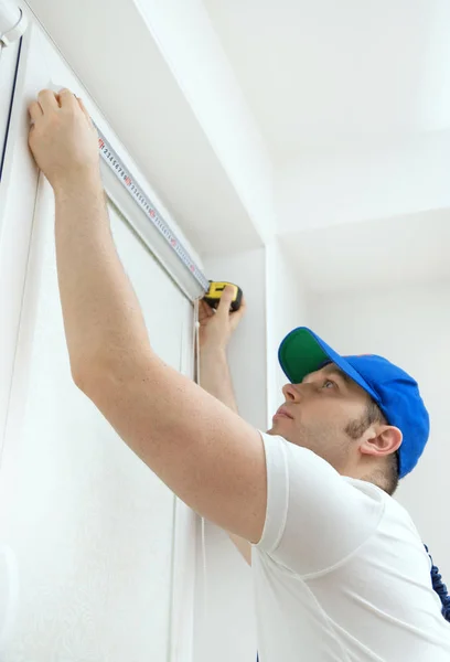 Manitas midiendo la ventana. Instalación de persianas enrollables de casete . — Foto de Stock